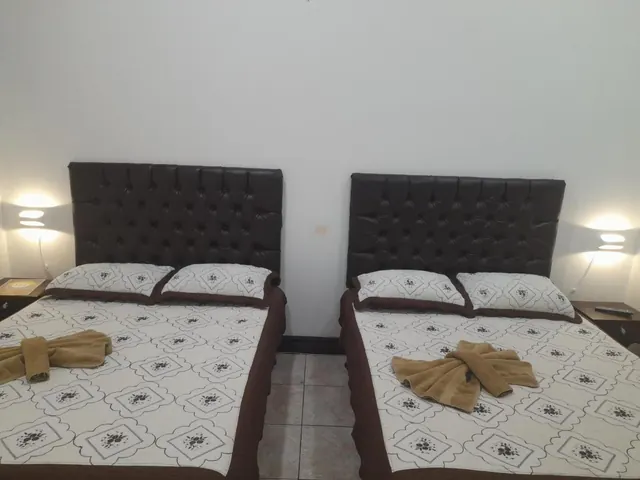 Habitación con dos camas dobles y lámparas de pared