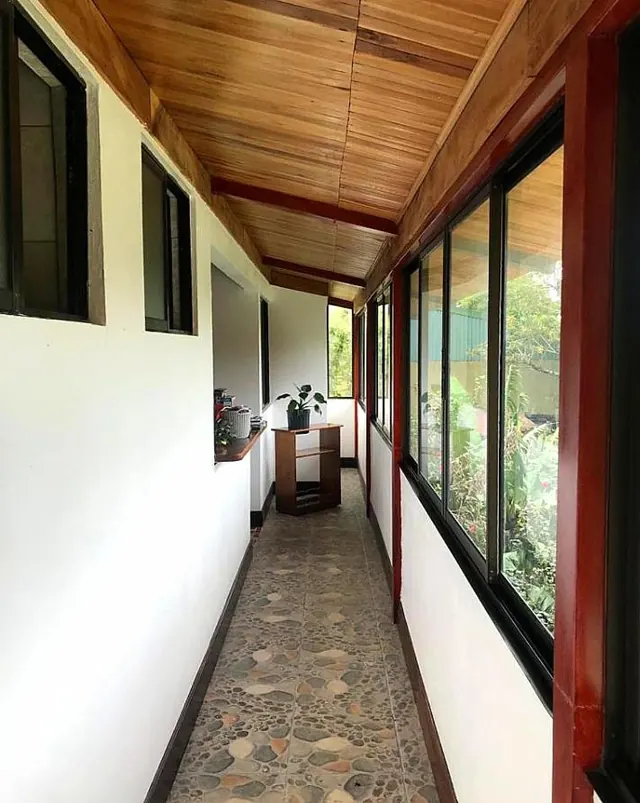Pasillo exterior del segundo piso con techo de madera